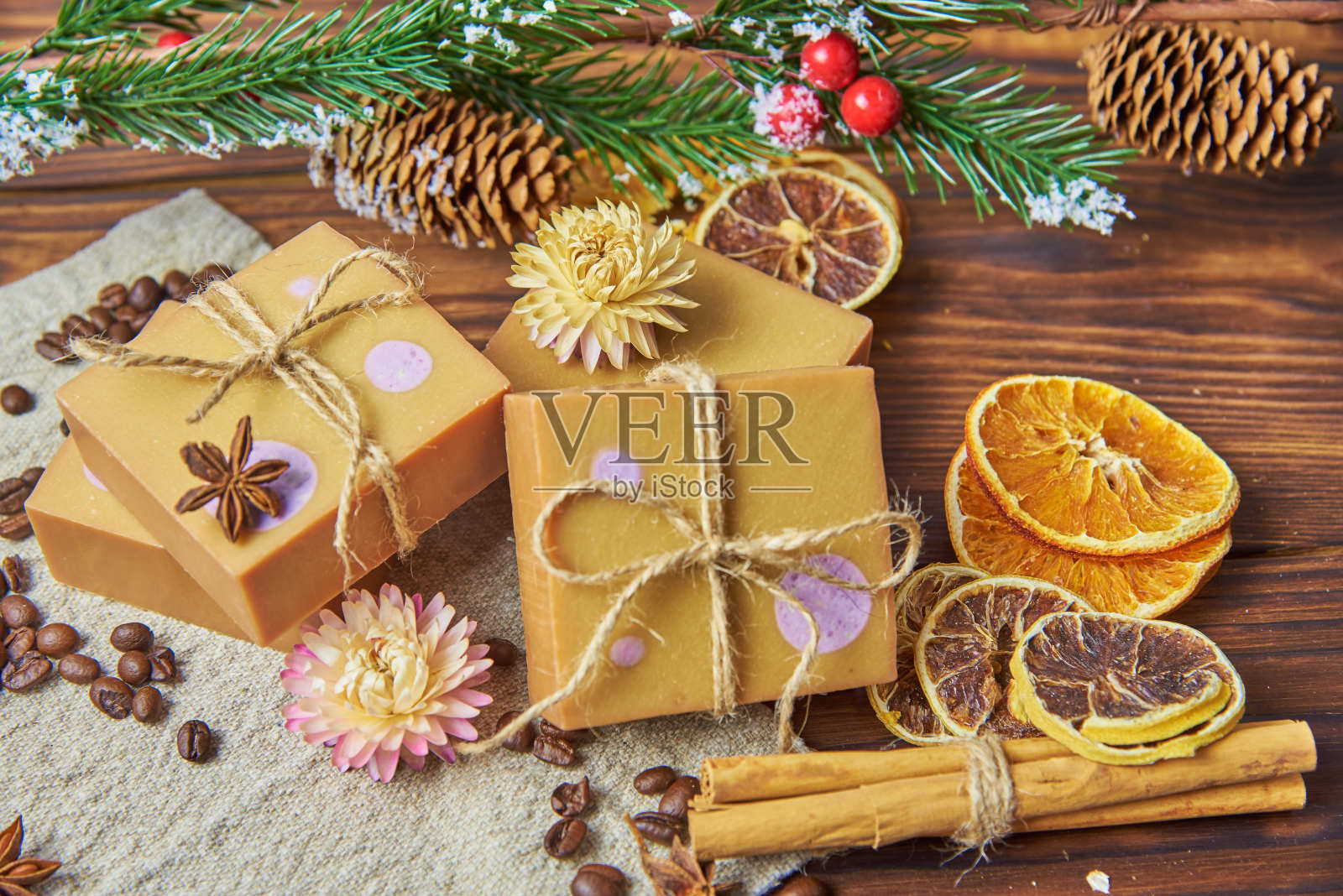 明亮的手工肥皂,木制的工作台面上放着各种香料。照片摄影图片