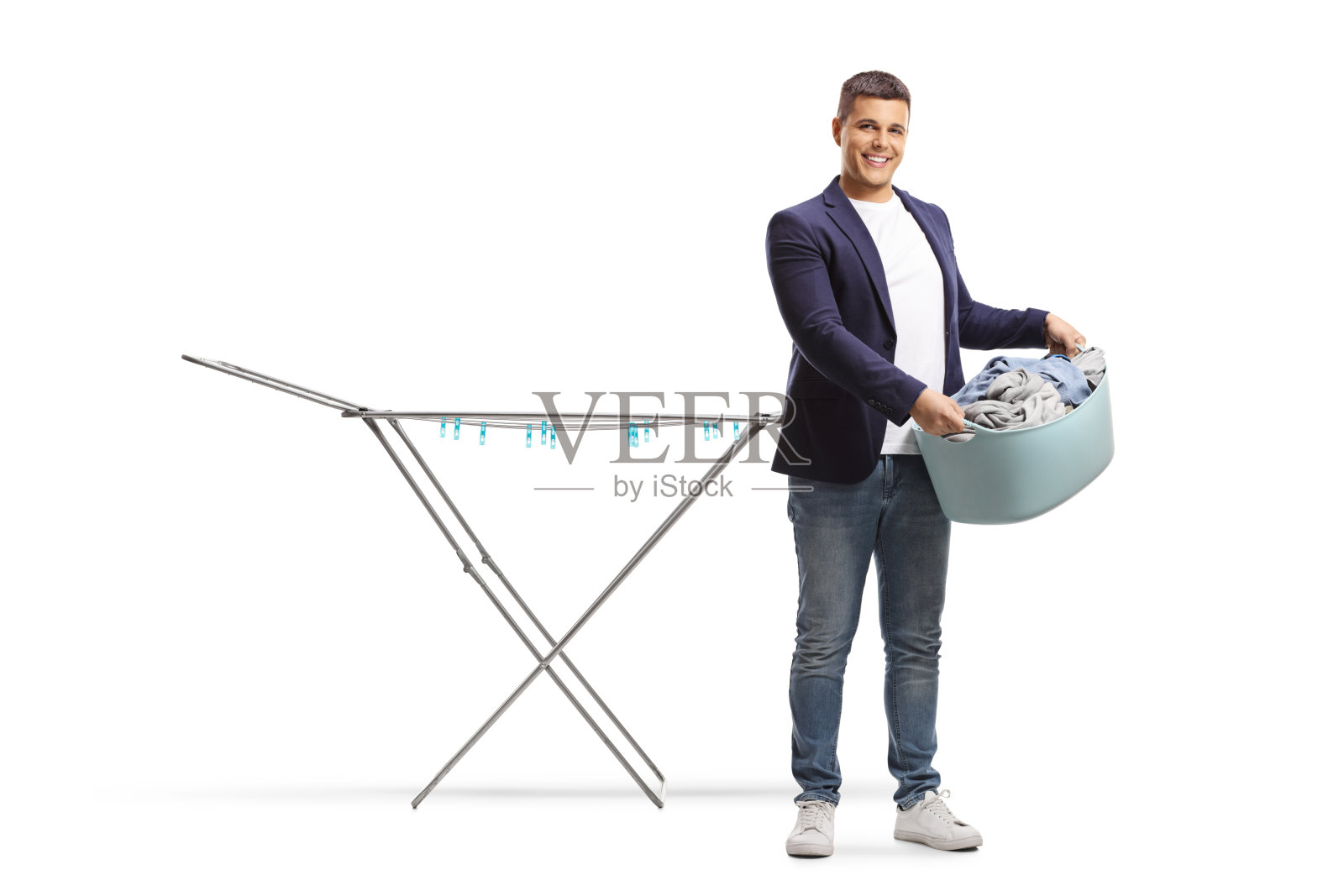 一个拿着洗衣篮的男人站在一个空的晾衣架旁边照片摄影图片