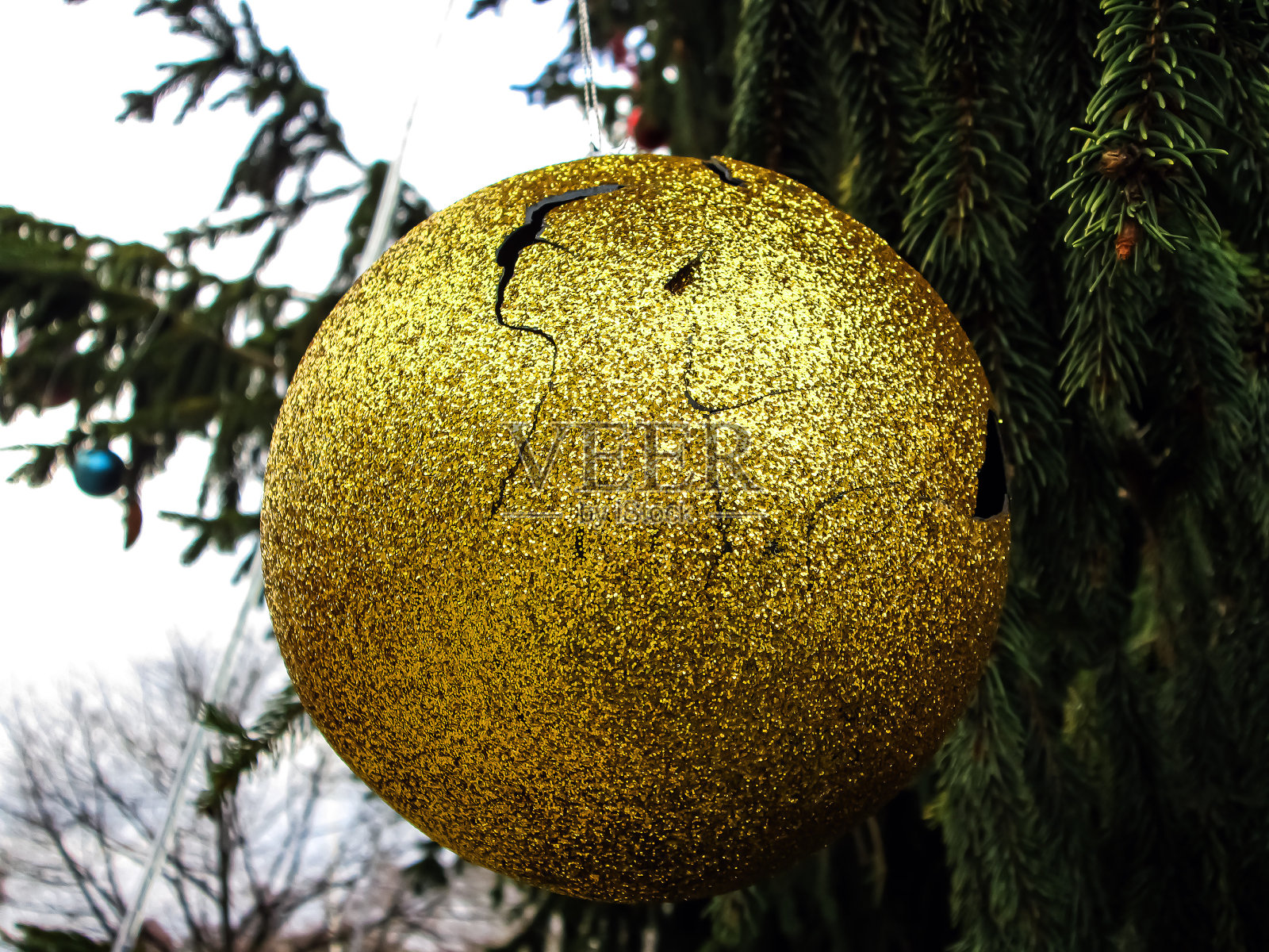 有裂缝的黄色圣诞玩具。照片摄影图片