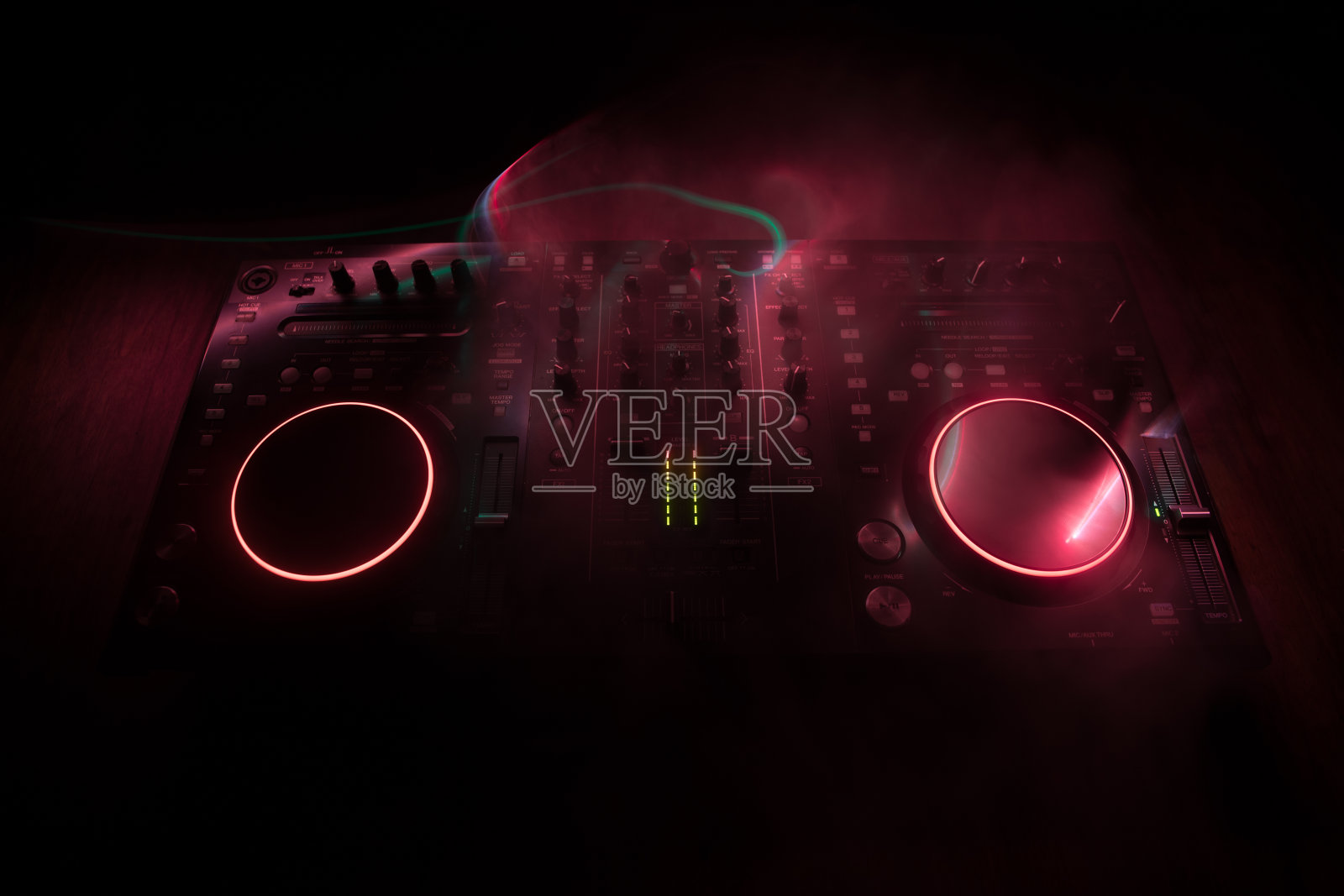 DJ控制台,DJ调音台,在黑暗中点缀着彩色的灯光。混音设备娱乐DJ站。照片摄影图片