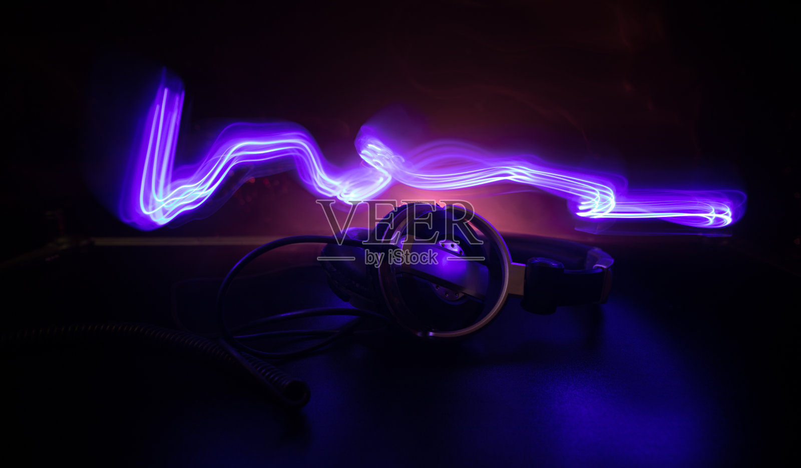 Dj音乐俱乐部概念。近距离耳机在黑暗背景与彩色的光。照片摄影图片