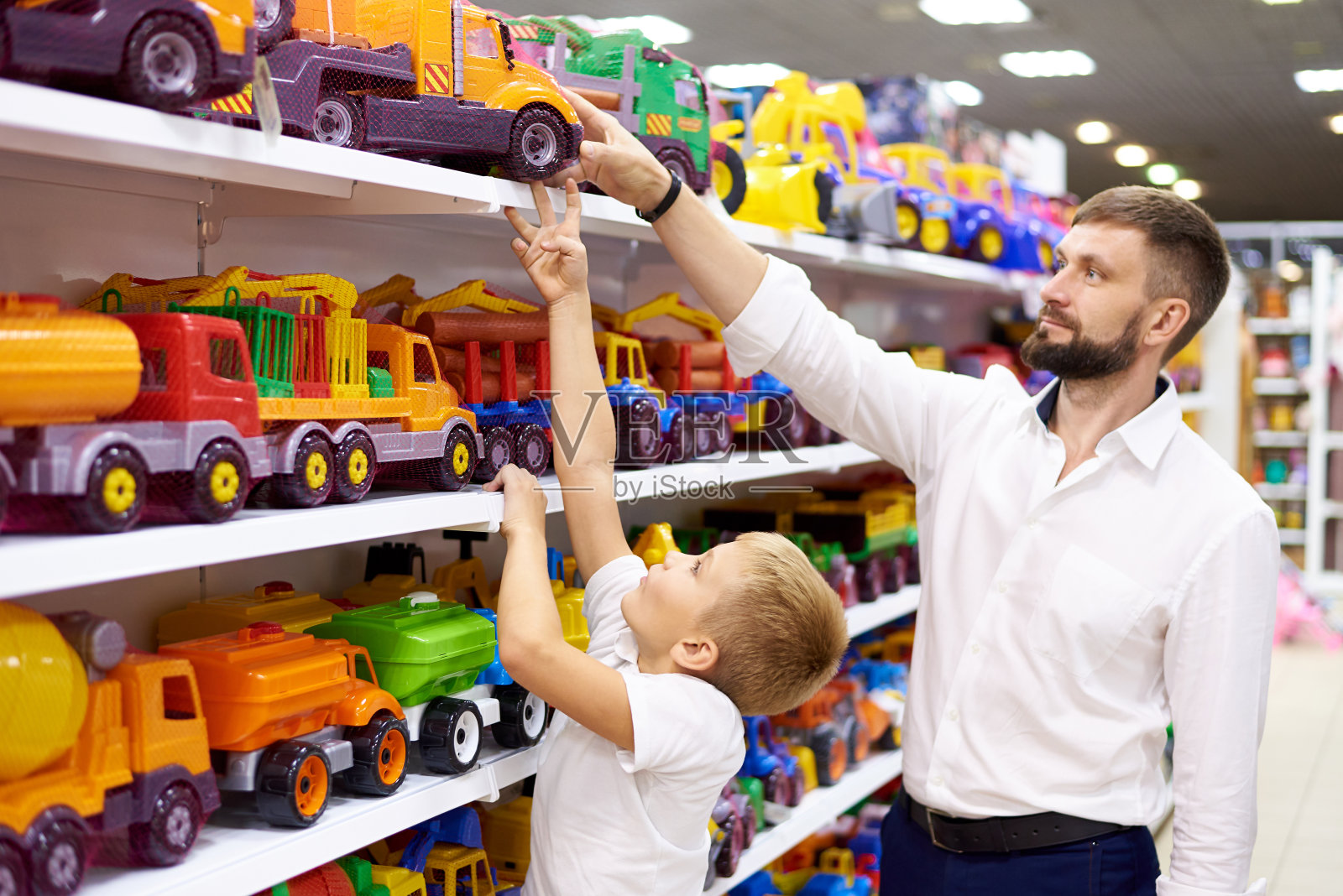 父子俩在玩具店买了一辆玩具车。照片摄影图片