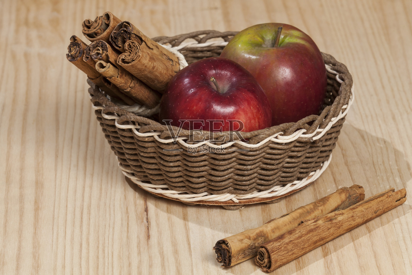 红苹果配肉桂棒;照片上的木制背景。照片摄影图片