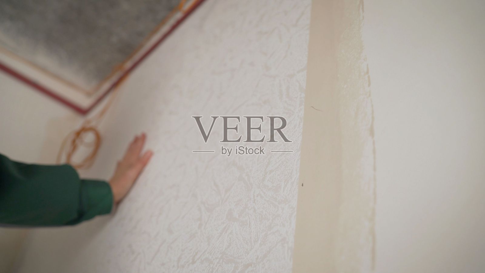 女人挂壁纸。女主在公寓里粘墙纸。修新楼。壁纸大师的服务。照片摄影图片