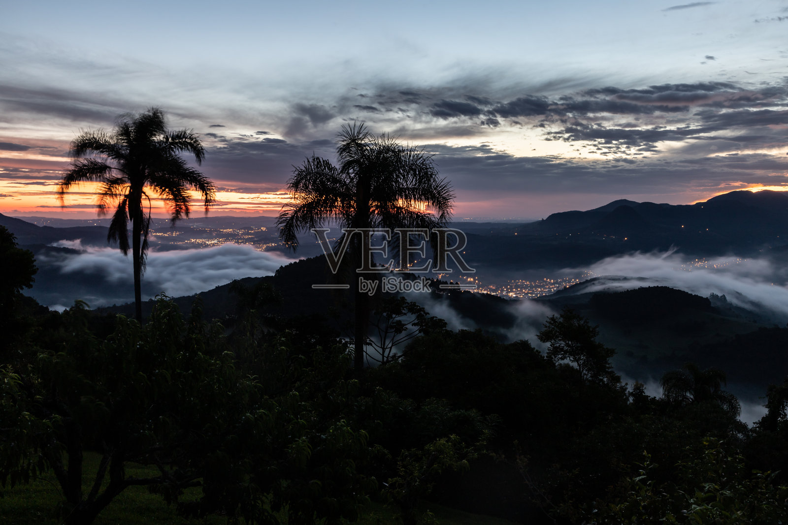 日落与树木,森林,山谷和城市灯光照片摄影图片