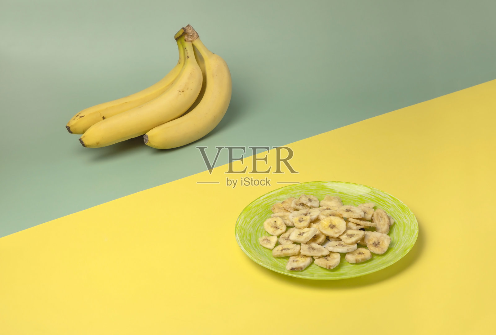 黄色背景的香蕉片,绿色背景的香蕉。健康的食物照片摄影图片