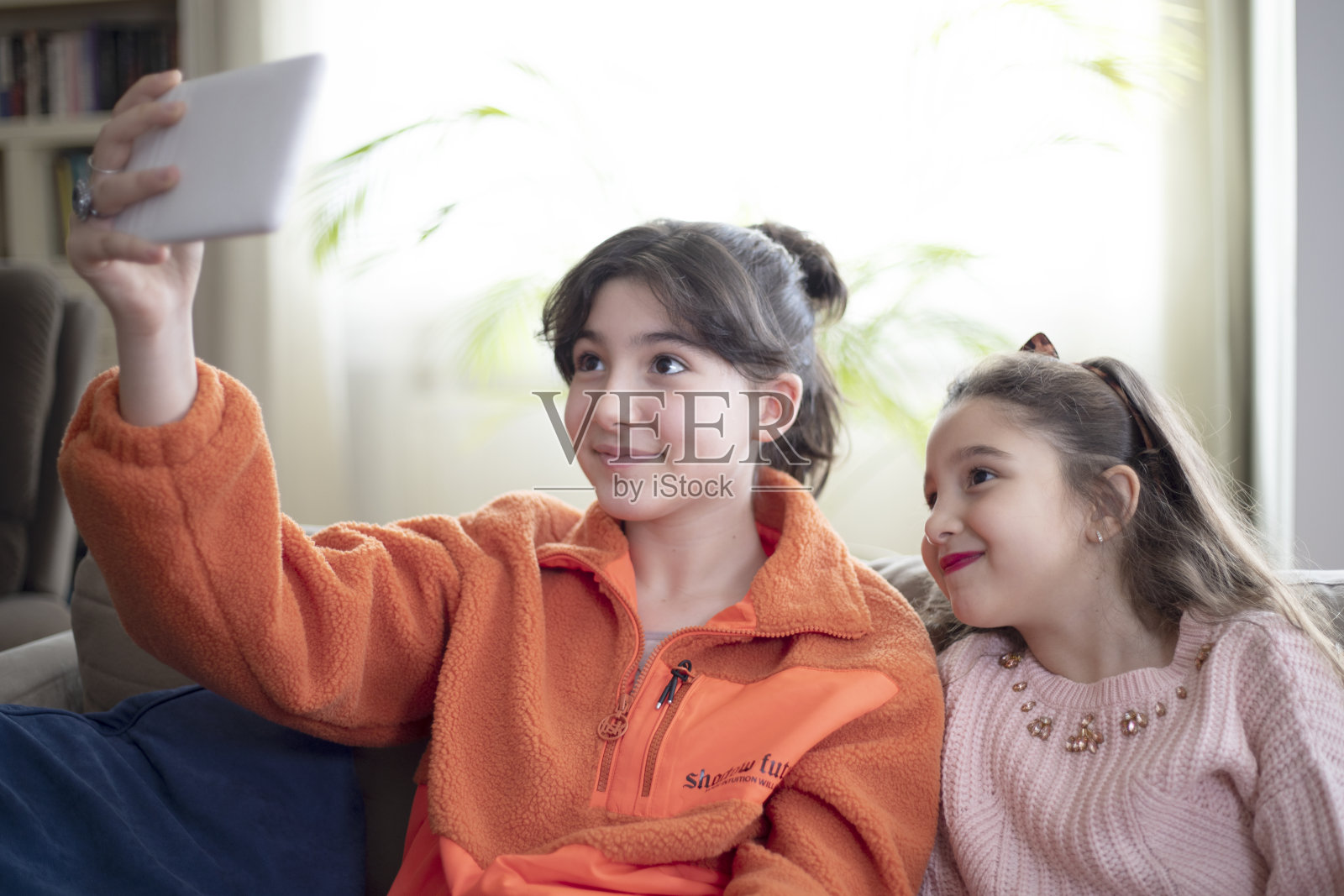 两个小女孩在平板电脑上看电影照片摄影图片