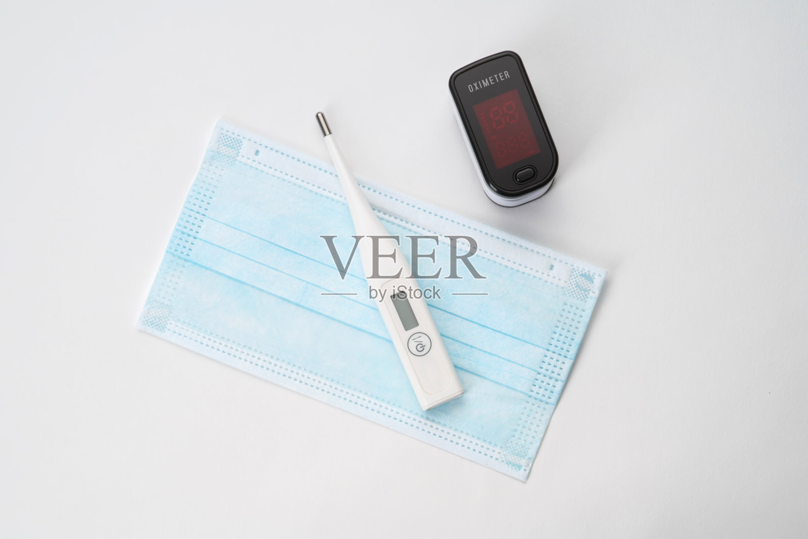 体温计,血氧计和外科口罩的顶角在白色背景上照片摄影图片