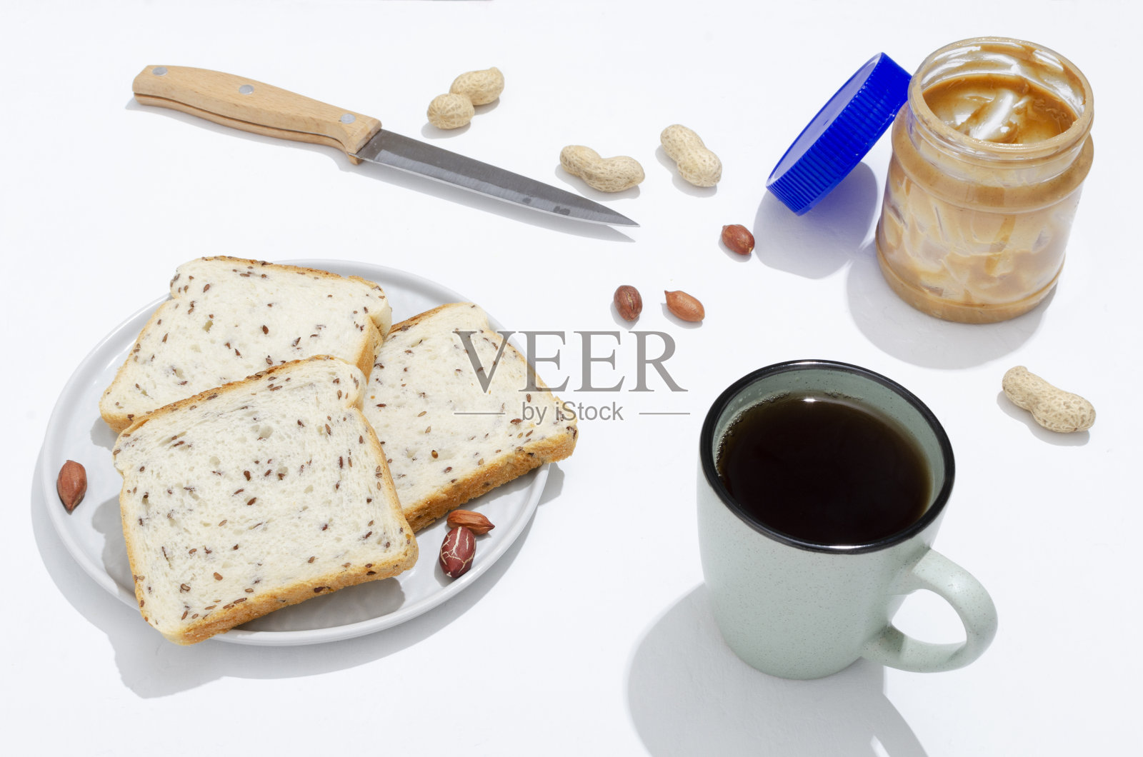 俯视图的一杯茶,有机面包片,花生酱在白色的桌子上照片摄影图片