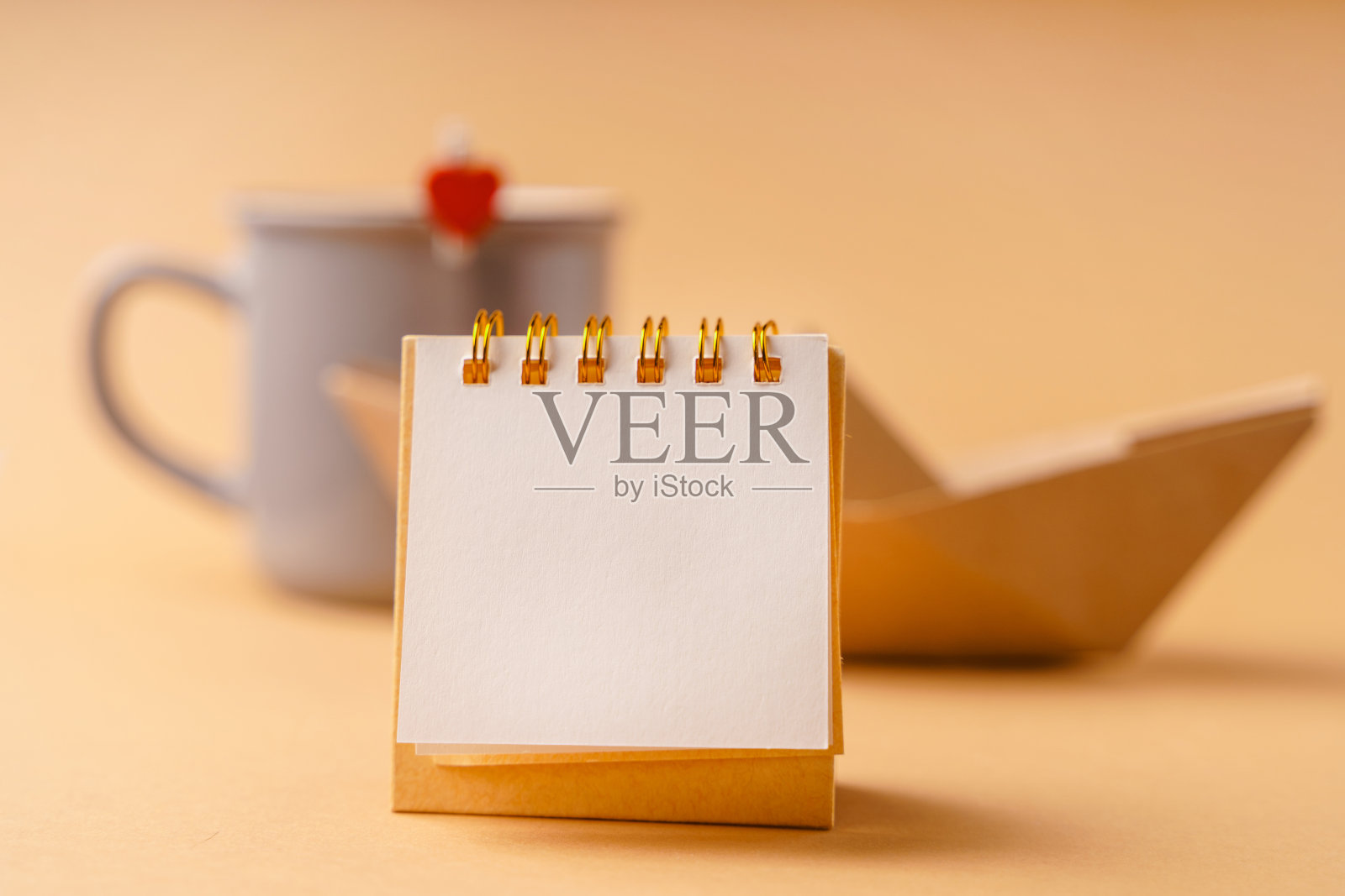 一个空的空白笔记本笔记在前景的背景与一个杯子的心和一个工艺纸船照片摄影图片