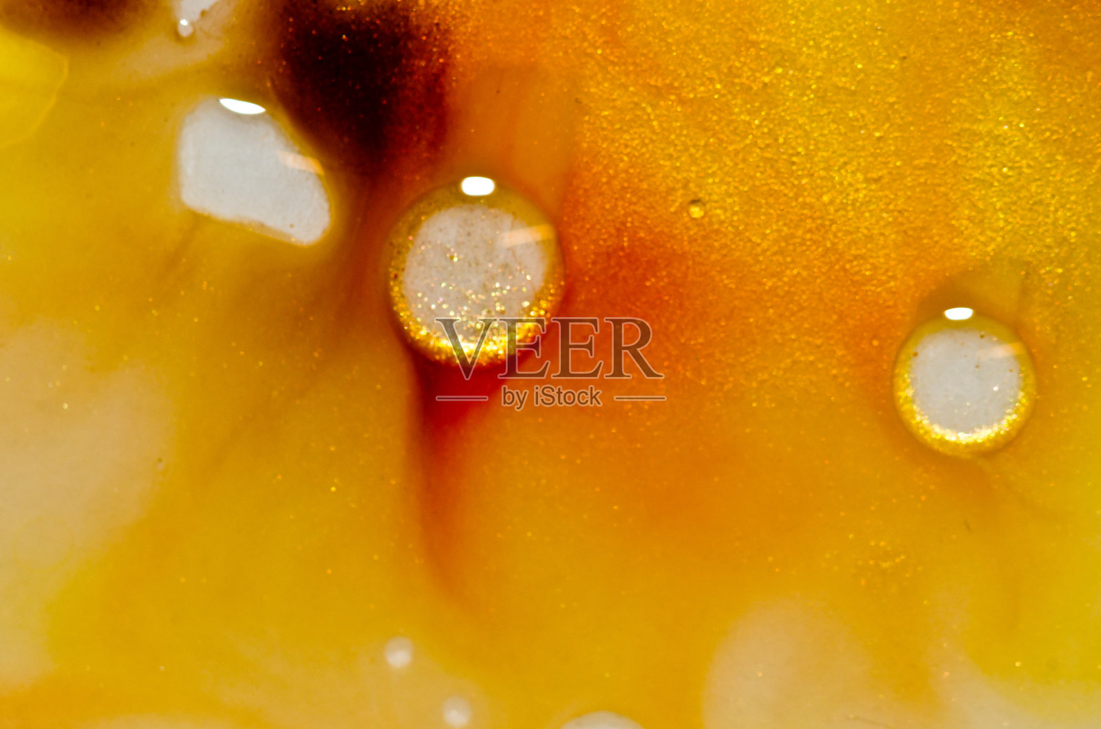 红色,橙色,黄色,棕色,白色和金色的液体明亮的颜色与油产生流体结构和气泡照片摄影图片