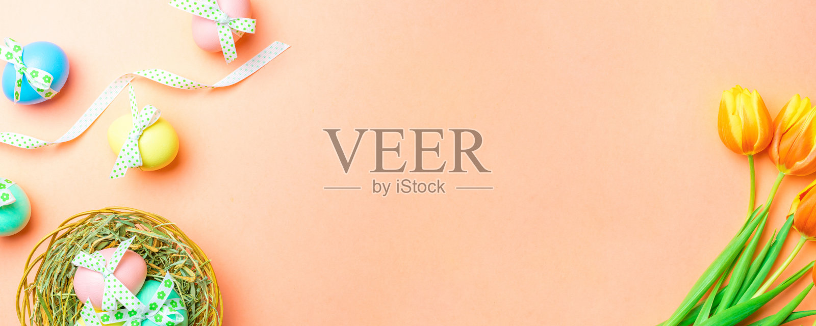 复活节兔子。彩色的彩蛋与丝带,春天的郁金香,羽毛在粉红色的背景在快乐复活节装饰。传统的横幅在顶视图。照片摄影图片