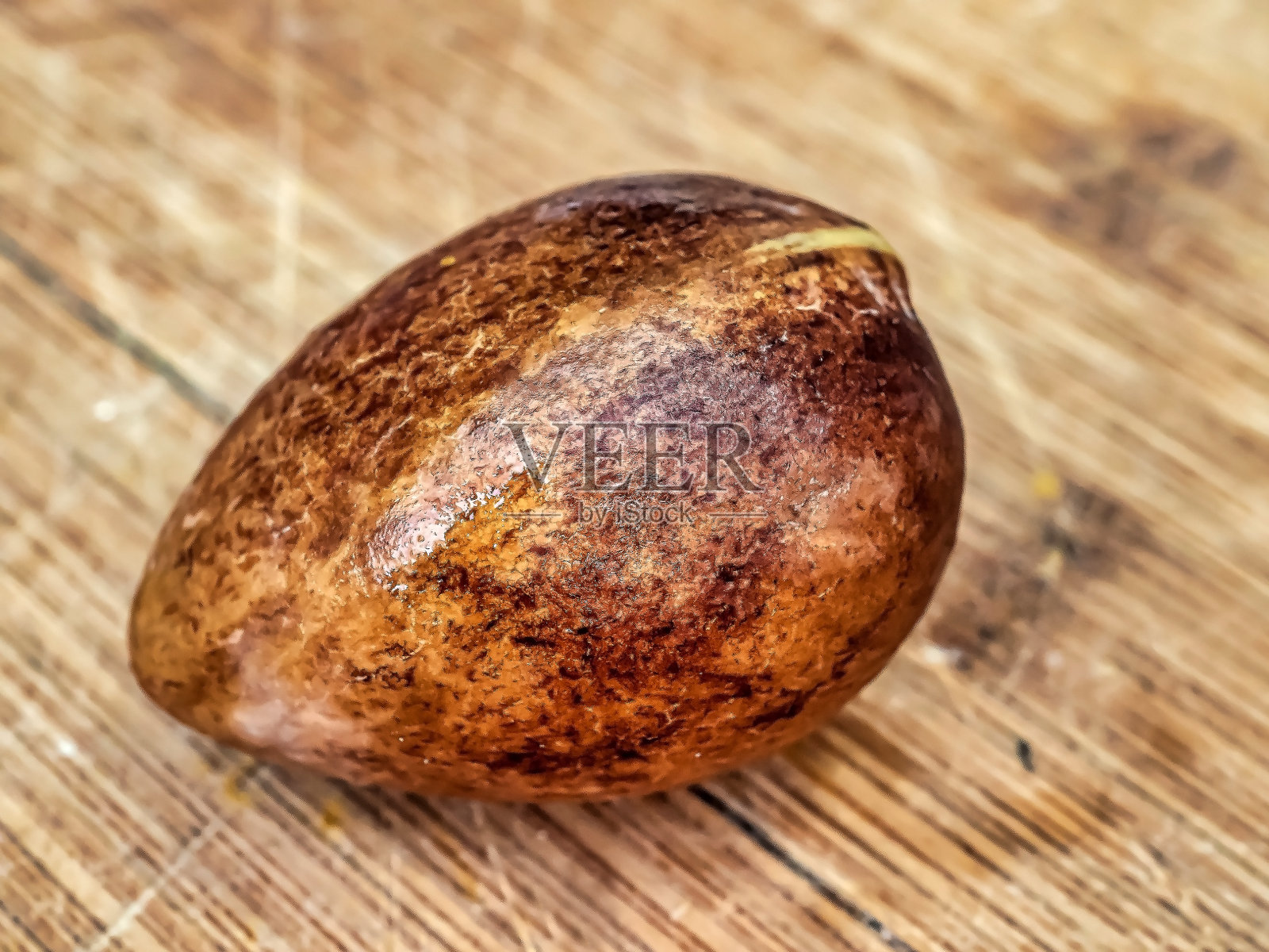 切菜板上的棕色牛油果种子照片摄影图片