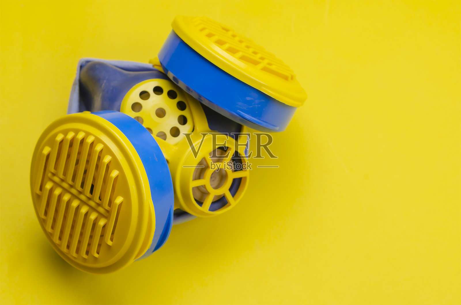 黄色背景上可更换过滤器的呼吸式半面罩。照片摄影图片