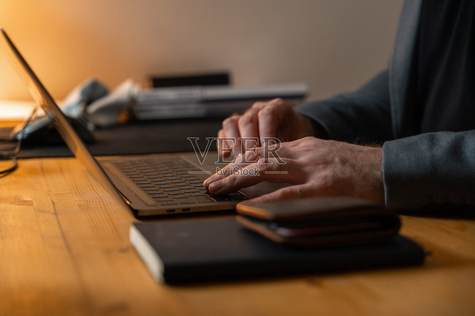 照片中的男性双手躺在笔记本电脑键盘上。库存图片照片摄影图片