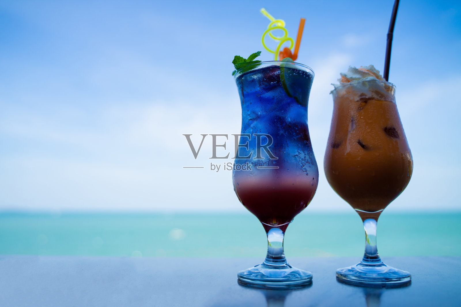 在轻松的一天,早上在海边的餐桌上喝一杯甜水照片摄影图片