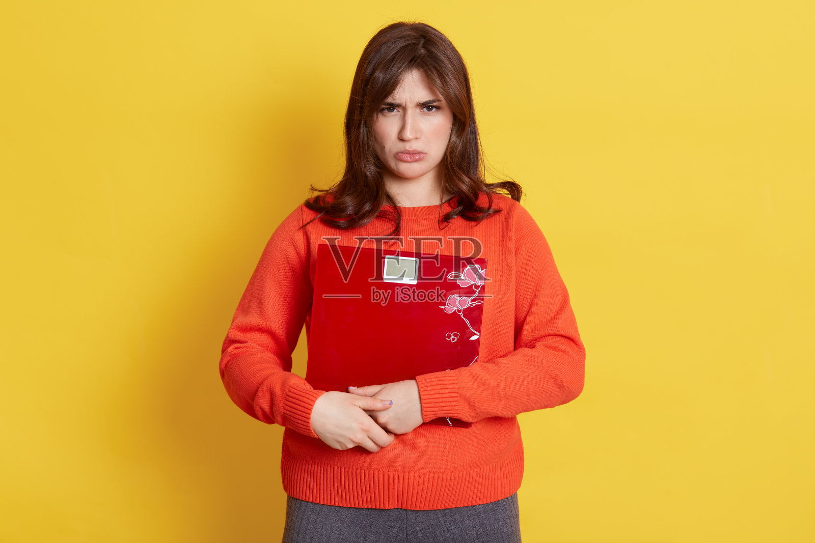 一名不高兴的白人女性手拿体重秤,悲伤地直视镜头,害怕变胖,需要节食,看起来很沮丧,表达悲伤。照片摄影图片