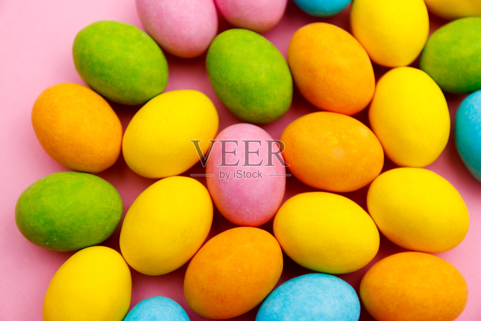 复活节兔子。复活节快乐节日背景概念。平铺彩色的兔子蛋与庆祝配件在现代乡村粉蜡笔在家庭办公桌上。照片摄影图片