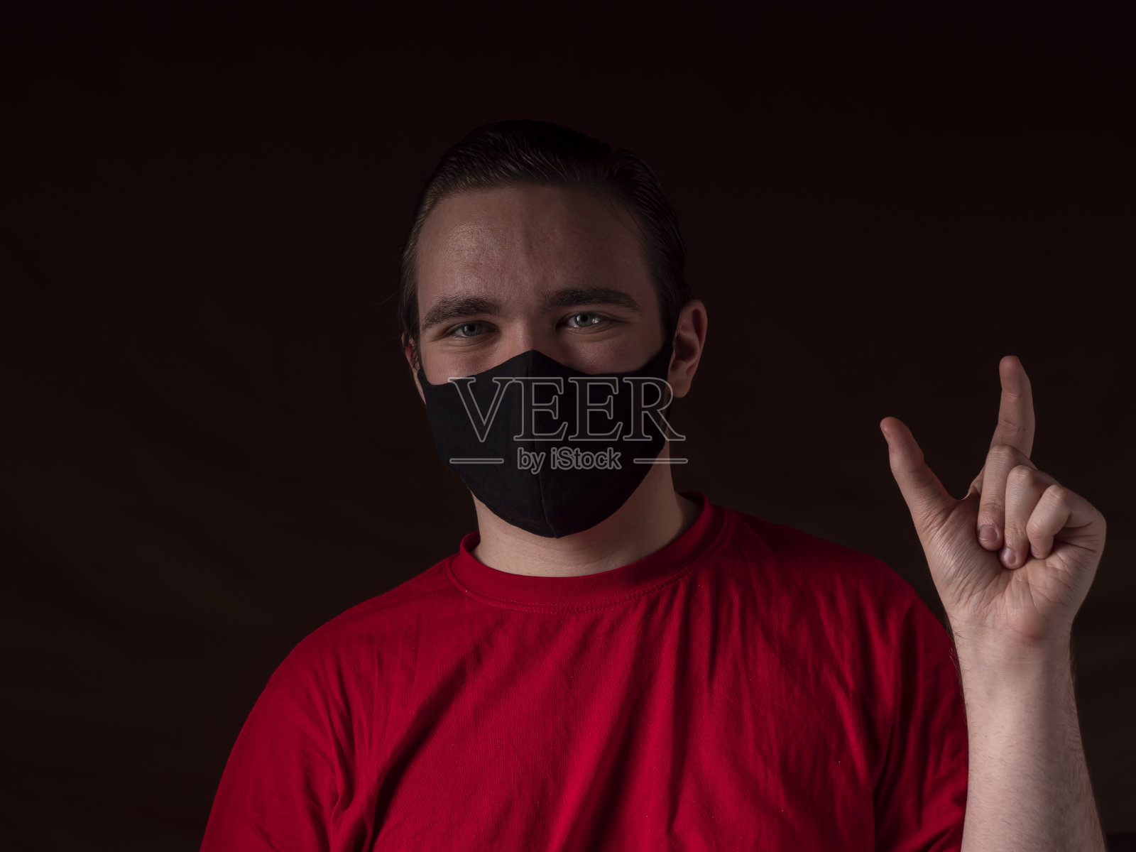 穿着红色t恤的年轻人看着镜头照片摄影图片