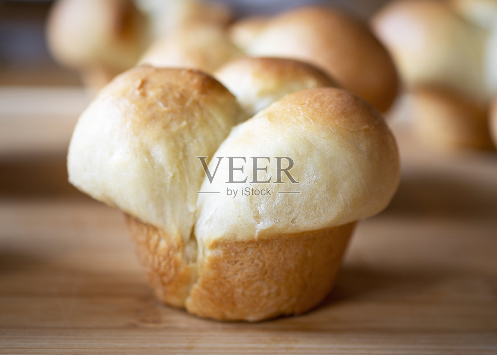 近侧视图的新鲜烤三叶草叶晚餐卷在竹切板。照片摄影图片