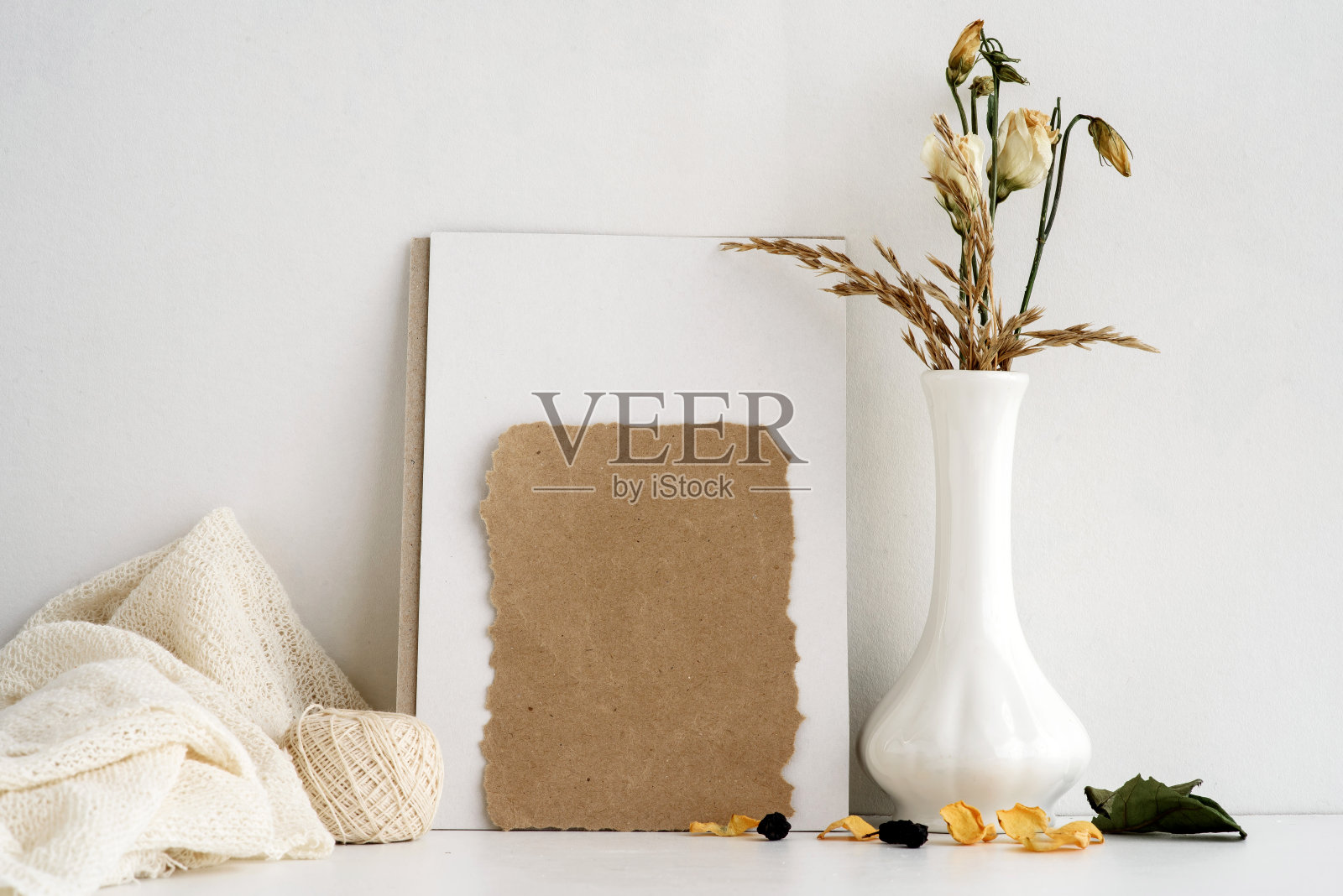 时尚股票文具背景上的白色背景。上面刻着字的空明信片和插在白色花瓶里的鲜花。婚礼的背景。邀请卡。照片摄影图片