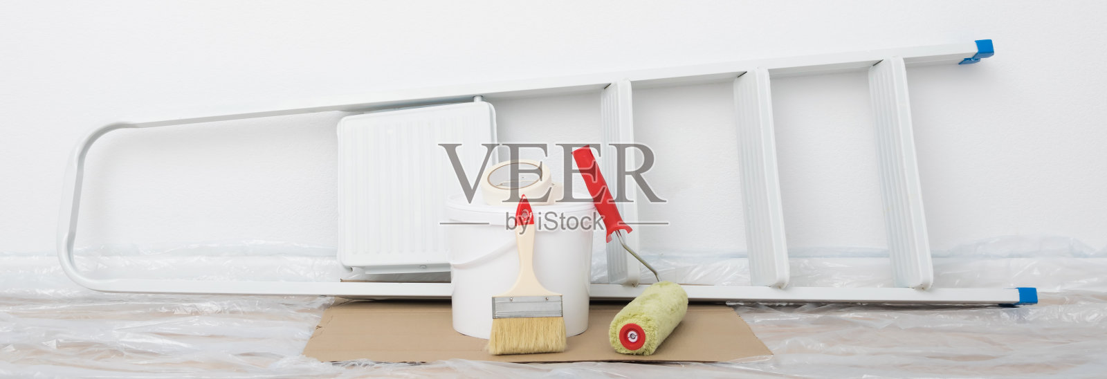 一架折叠梯,一桶白色的油漆和工具正站在白墙上,准备室内整理工作,长照照片摄影图片