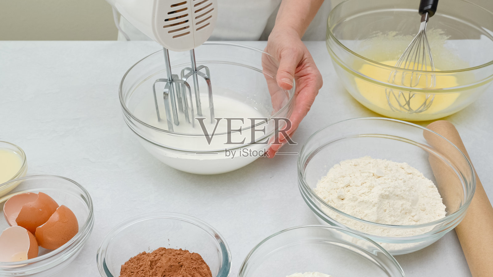 巧克力蛋糕的一步一步食谱。女人用手搅拌蛋清。关闭准备过程照片摄影图片