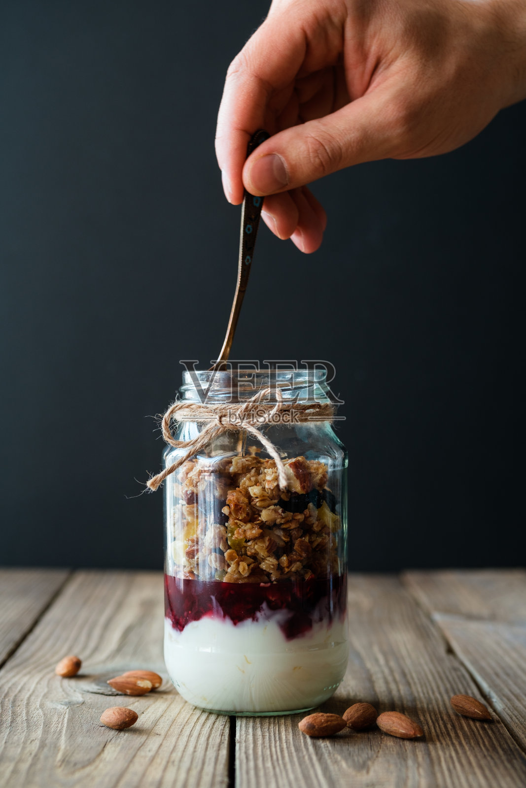 一罐加了酸奶果酱和蜂蜜的格兰诺拉麦片照片摄影图片