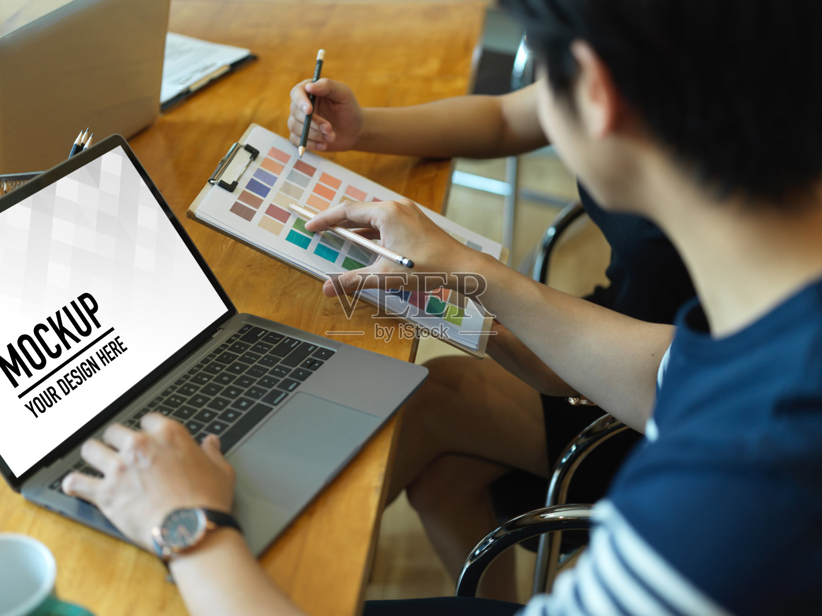 两名设计师在办公室用笔记本电脑和颜色表讨论他们的项目照片摄影图片