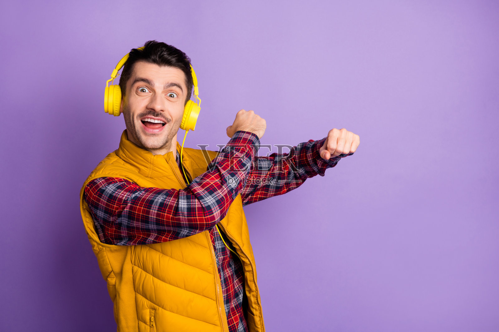 滑稽的funky快乐的男子舞蹈戴耳机听音乐嬉皮士孤立在紫色的背景照片摄影图片