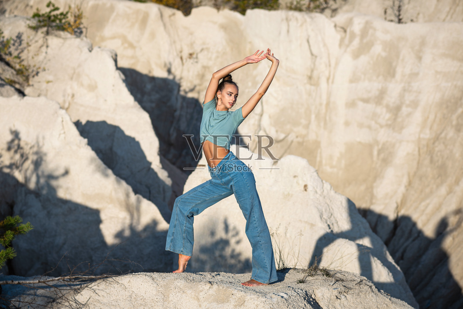 苗条的女人在白山做瑜伽练习。这女孩在大自然中旅行。在山顶放松瑜伽照片摄影图片