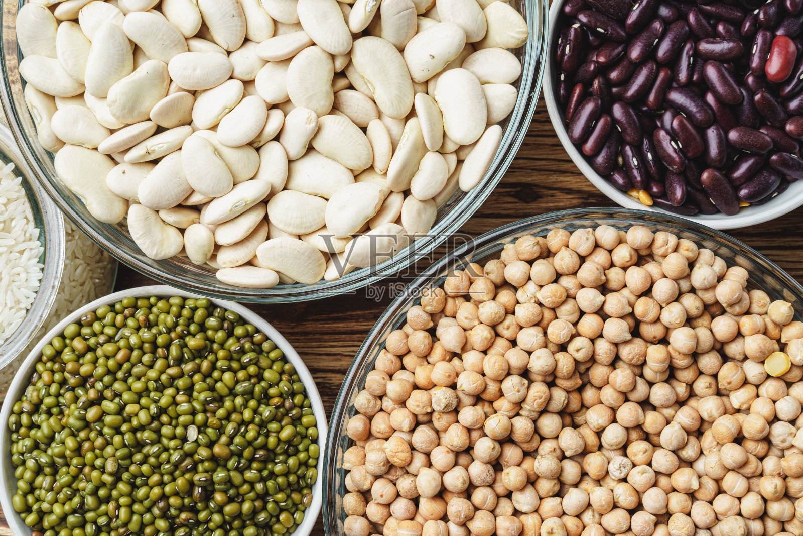 各种各样的豆子在木制背景上。关闭了。照片摄影图片