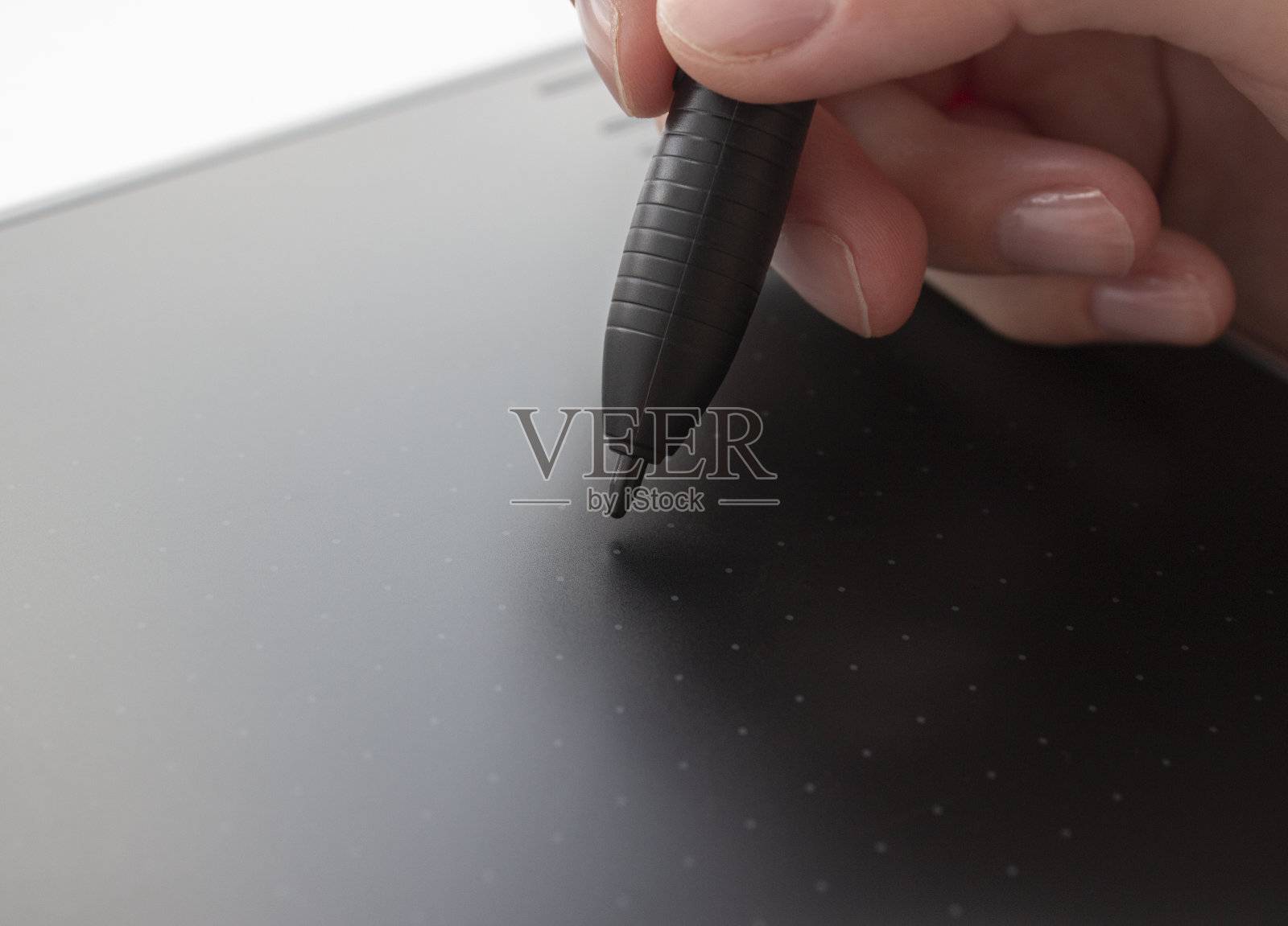 一个人在绘图板上画画。手握着触笔。有线图形平板电脑的设计师和艺术家。一名男子在平板电脑上工作的特写镜头。照片摄影图片