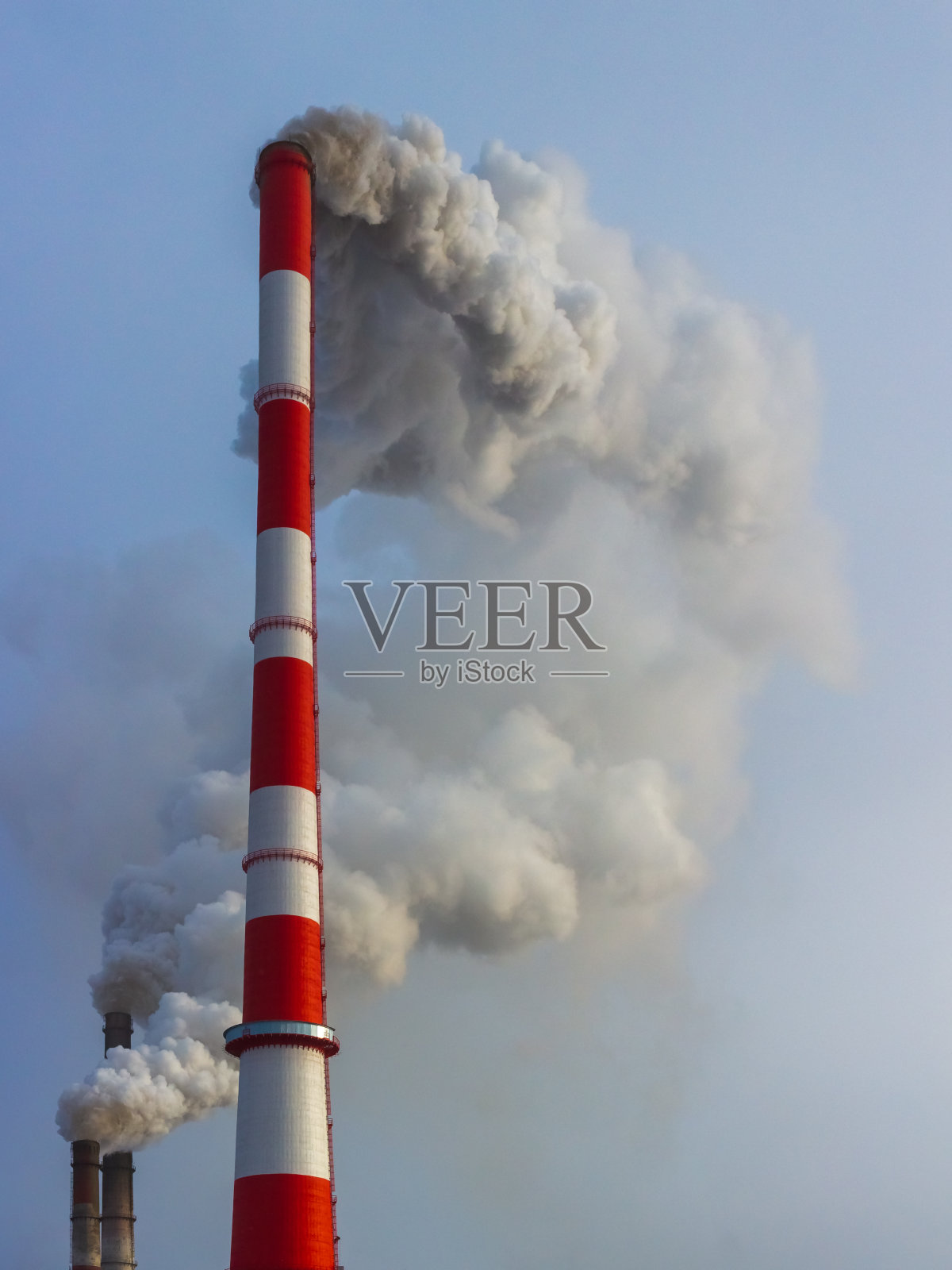 工业浓烟从烟囱里飘向蓝天。空气污染的背景照片摄影图片