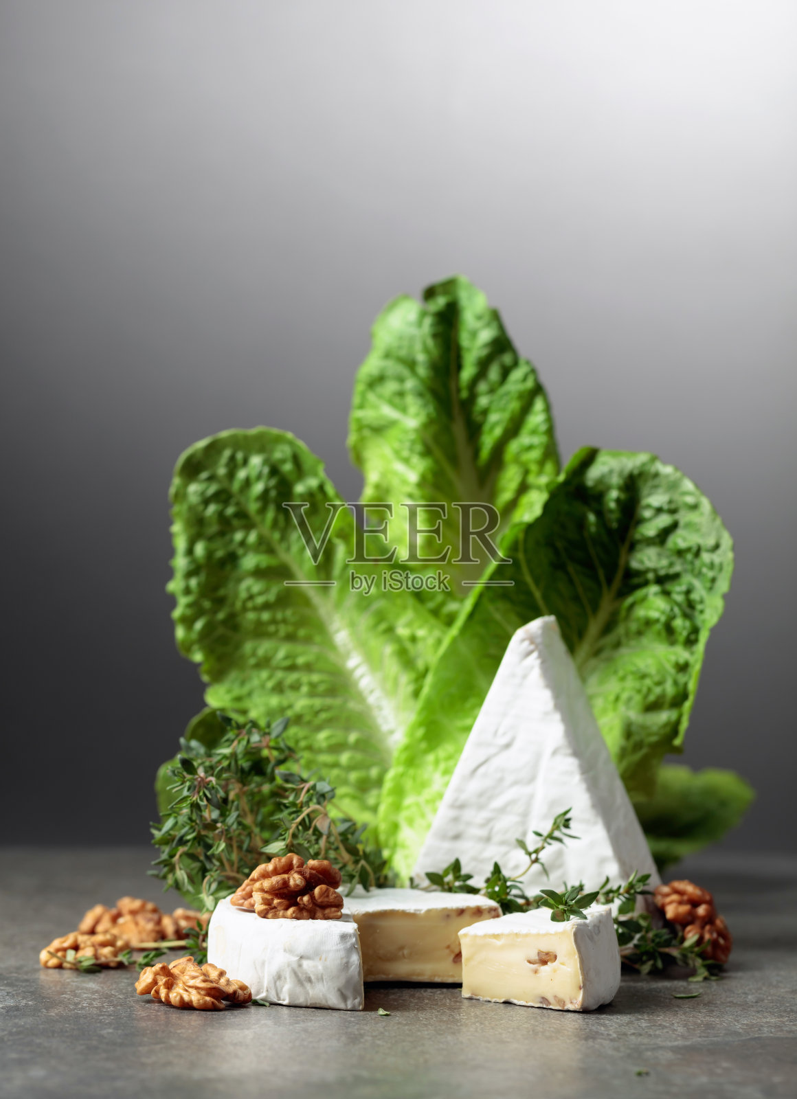 新鲜的布里干酪配生菜,百里香和核桃。照片摄影图片