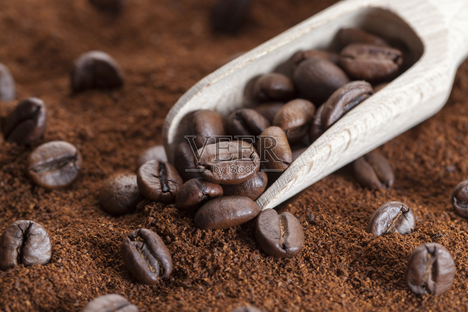 将烘好的咖啡豆放在磨碎的咖啡上照片摄影图片