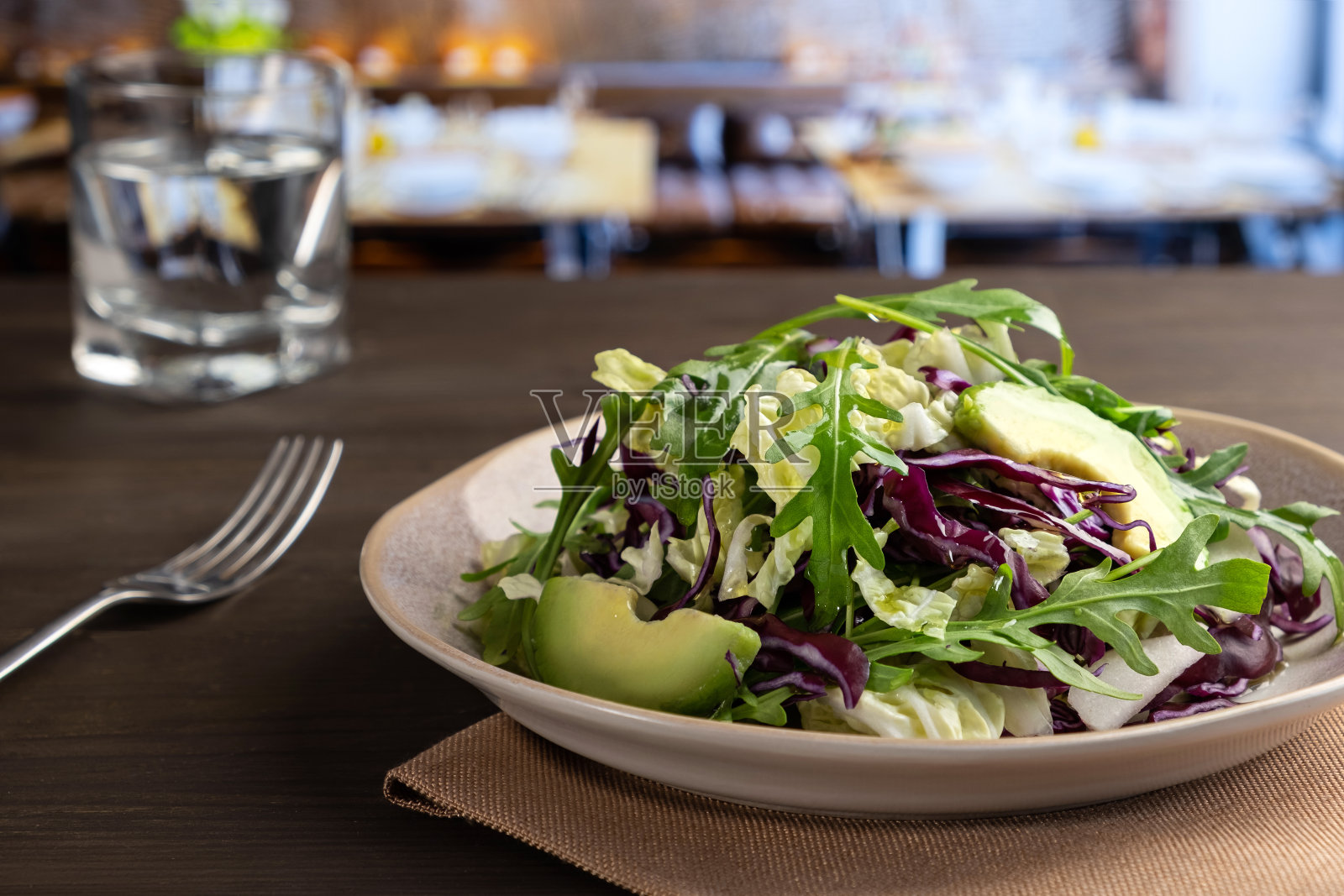 咖啡馆的木桌上放着蔬菜沙拉。特写镜头照片摄影图片