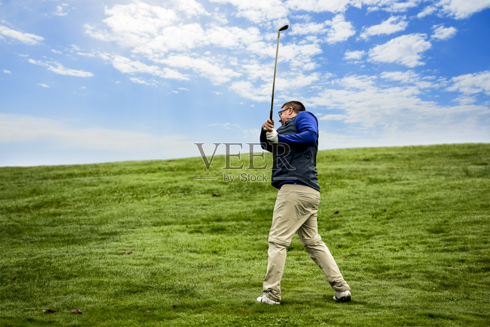 一位高尔夫球手正把高尔夫球打到果岭照片摄影图片