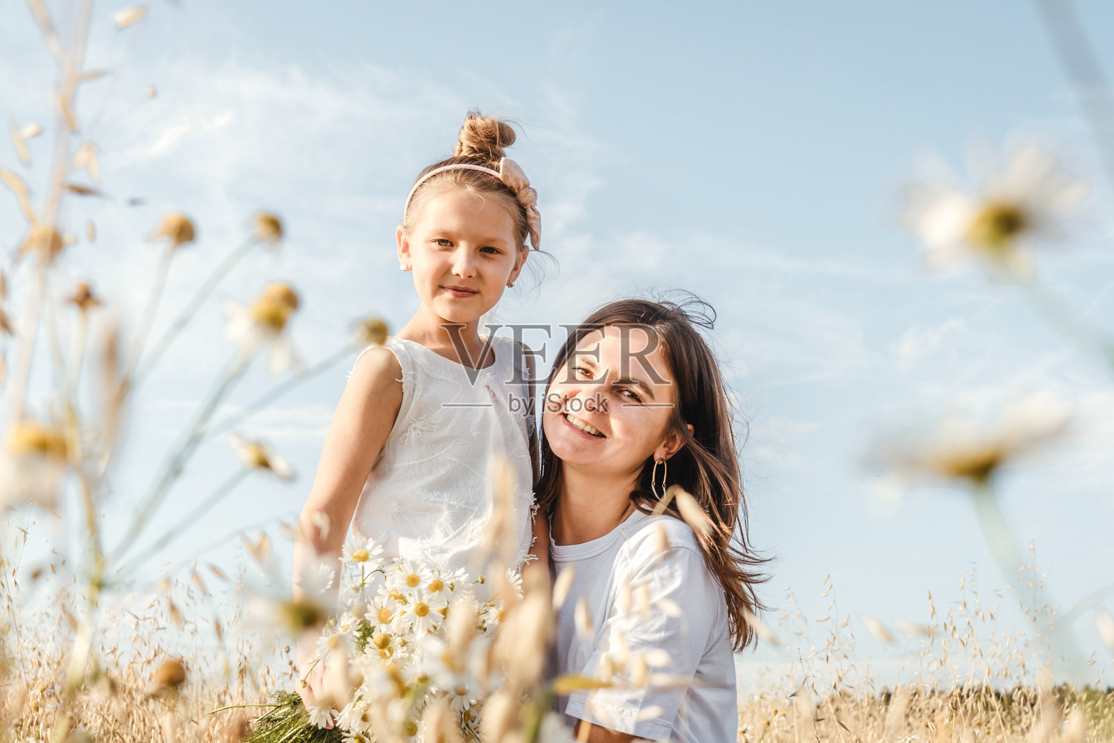 年轻的母亲和女儿在户外玩。照片摄影图片