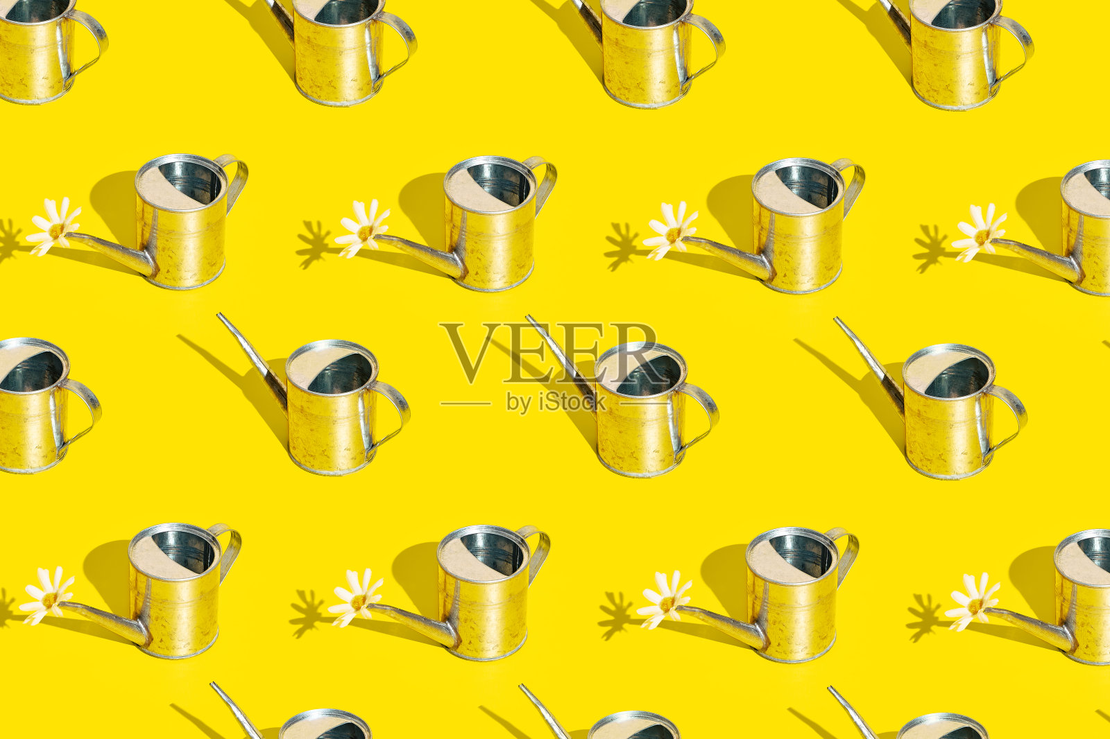 亮黄色背景上的金属喷壶。花园可以有阳光和阴影。夏、春、园格局照片摄影图片