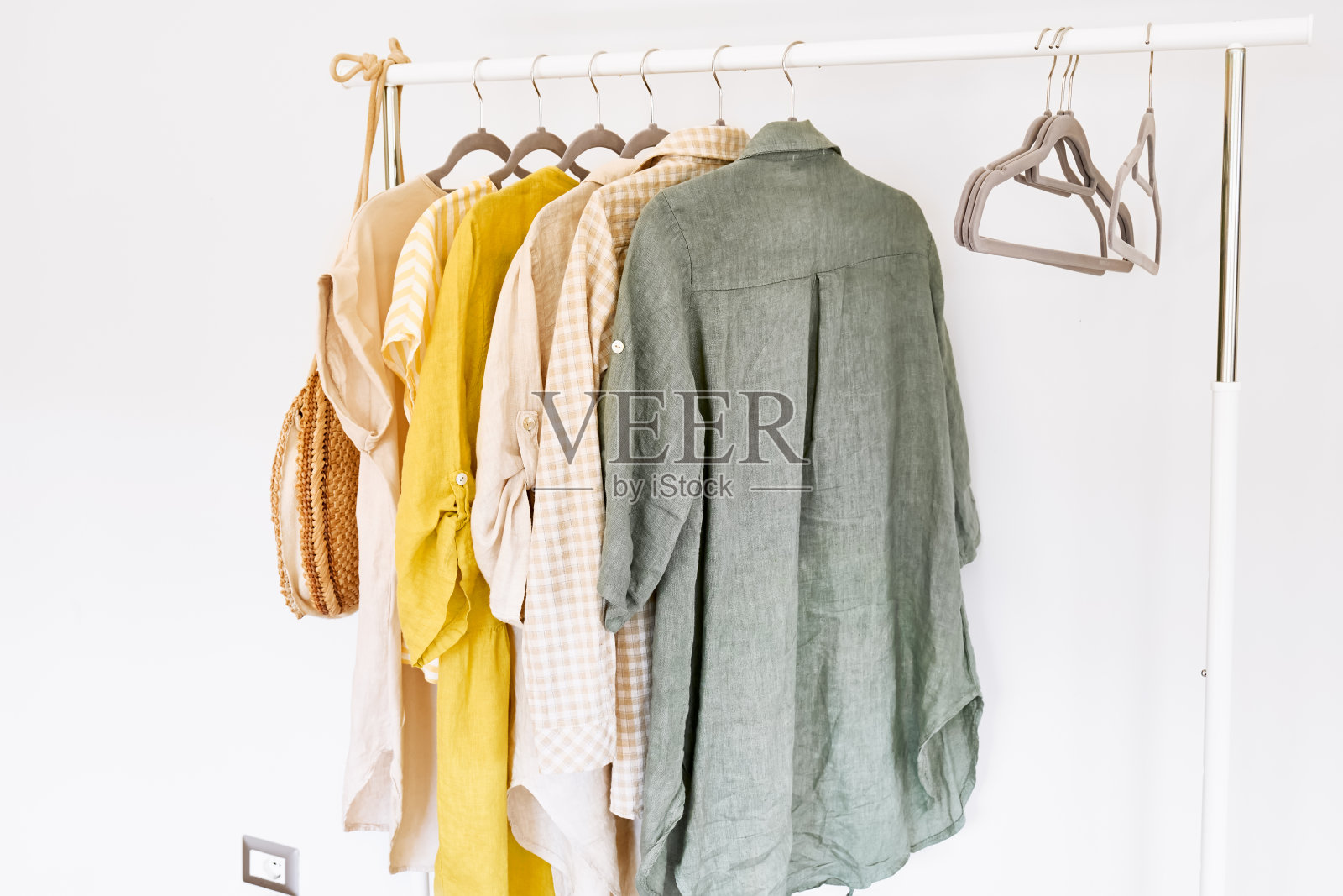 亚麻衣服放在衣架上的灰色衣架上。慢时尚。有意识的消费。时尚业、零售业的危机。环保、可持续的季节性销售理念。“零浪费”。照片摄影图片