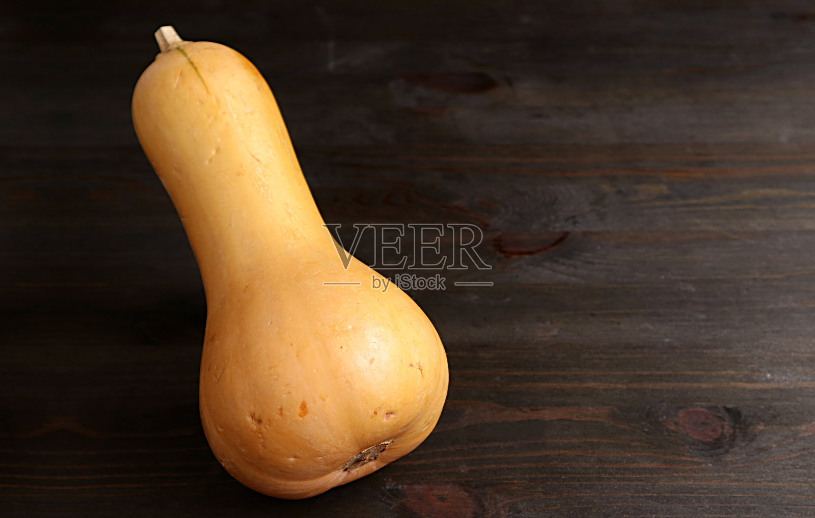 成熟的冬南瓜孤立在深棕色木桌上照片摄影图片