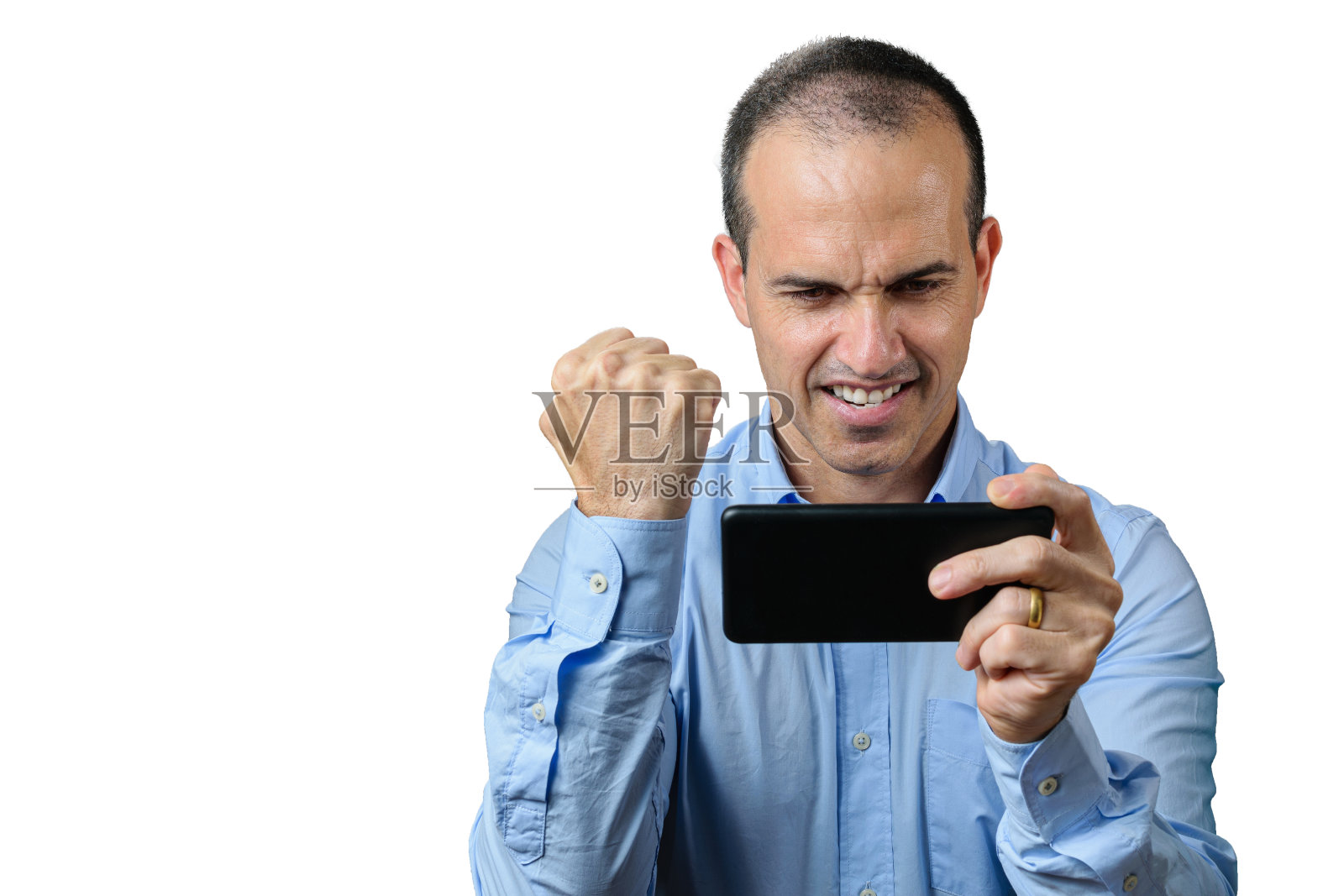 成熟的男人穿着正装玩着他的智能手机,握紧拳头庆祝。照片摄影图片