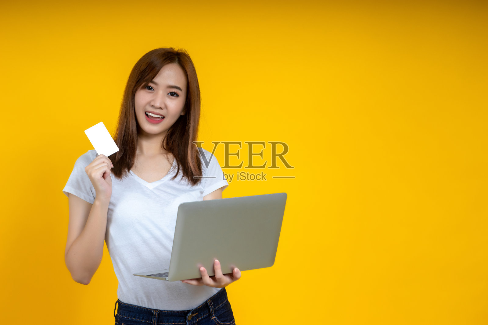 新冠肺炎疫情爆发期间,亚洲女性用笔记本电脑愉快网购。照片摄影图片