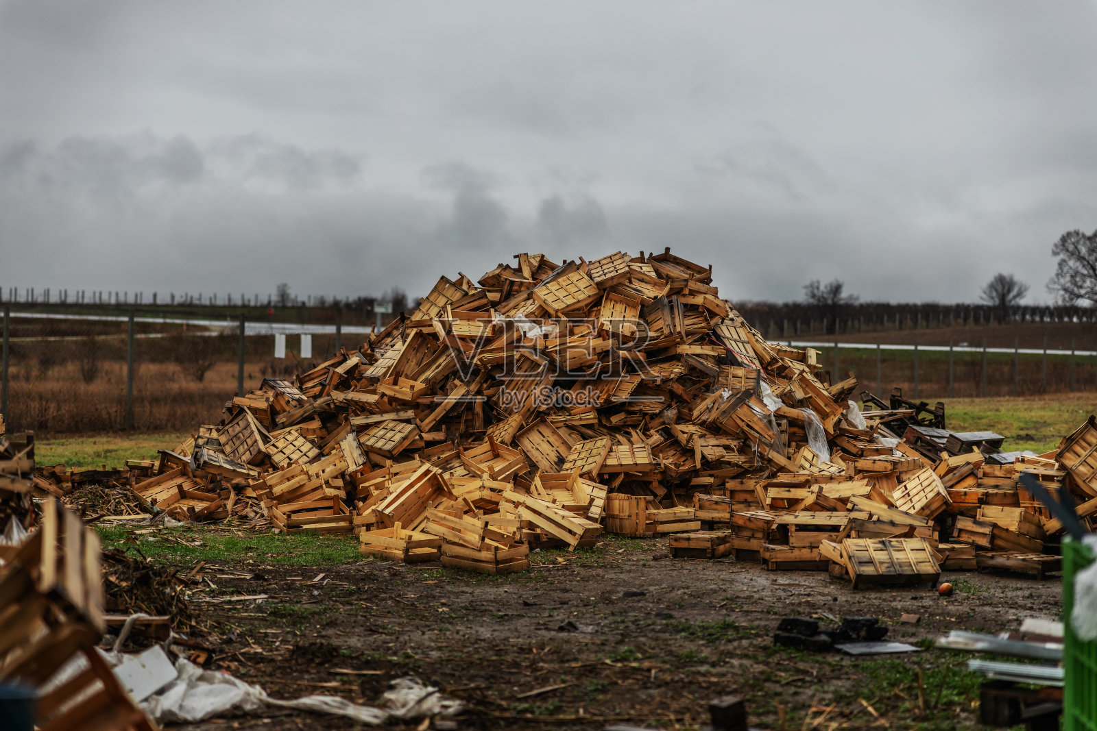 垃圾填埋场上用过的破板条箱。照片摄影图片