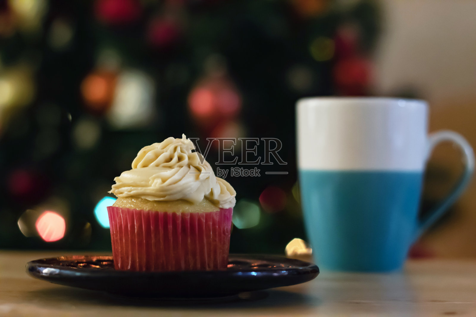 有糖霜的纸杯蛋糕,放在一张木桌上,背景是一些博克蛋糕照片摄影图片