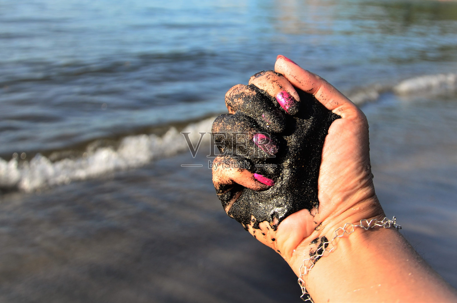 手上有湿的独居石砂照片摄影图片