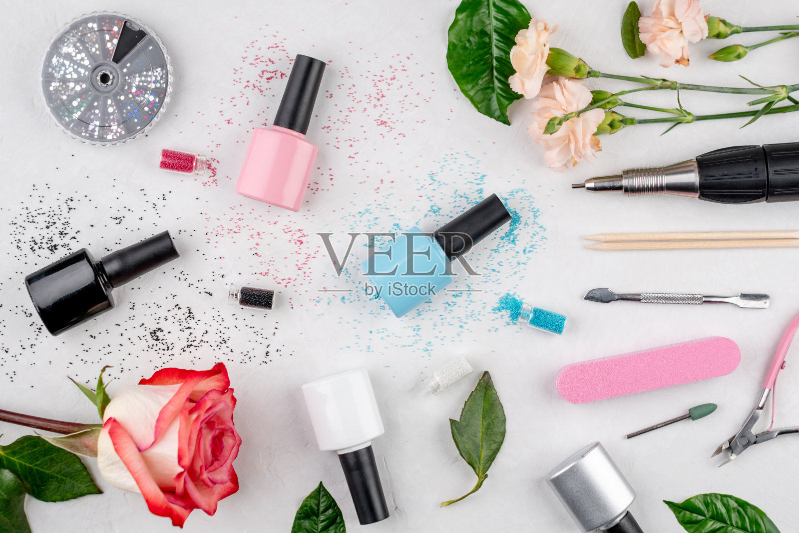 彩色的瓶子指甲油和工具和配件的美甲和足疗程序在白色的背景。俯视图照片摄影图片