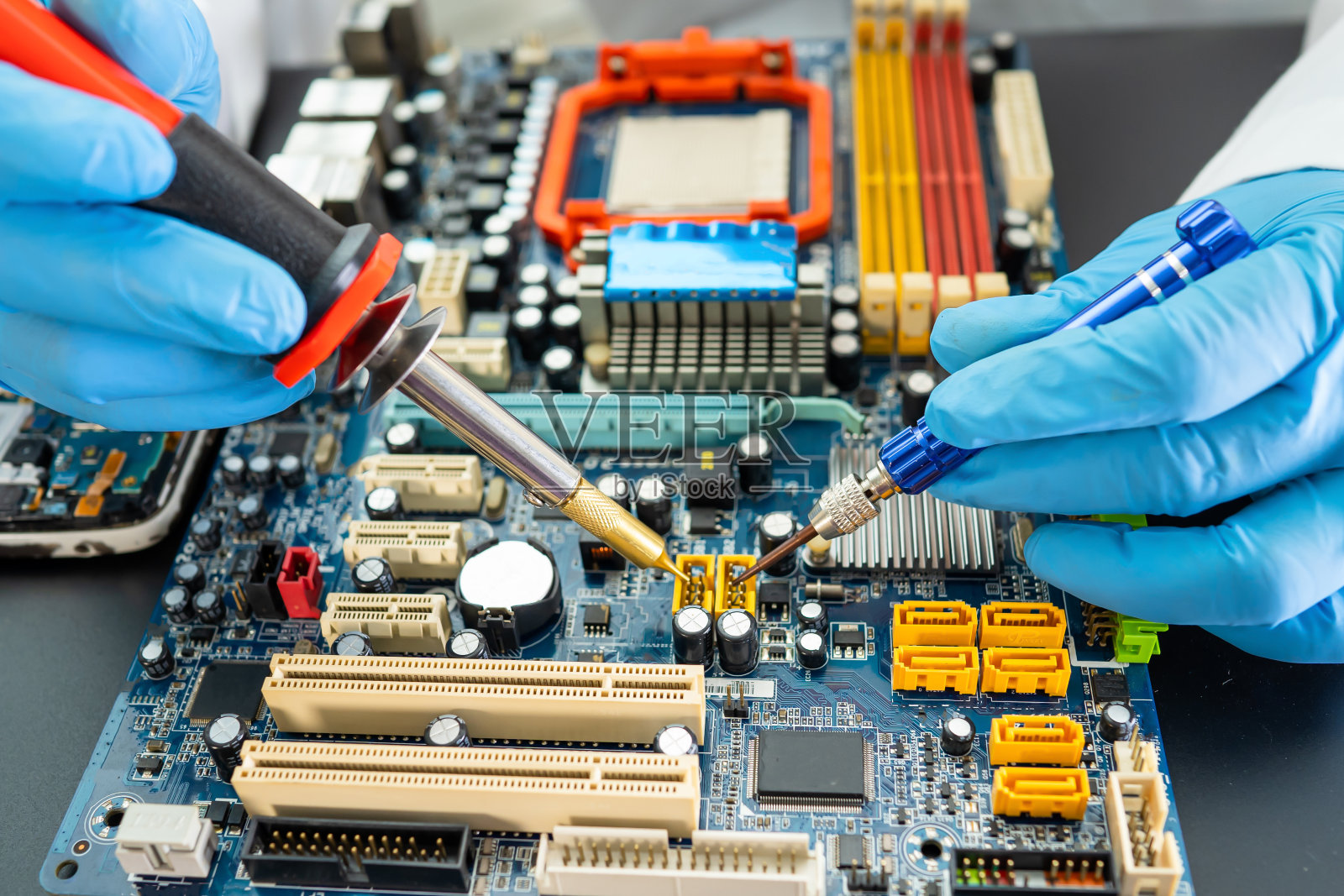 技术员用烙铁修理硬盘内部。集成电路。数据、硬件、技术和技术的概念。照片摄影图片