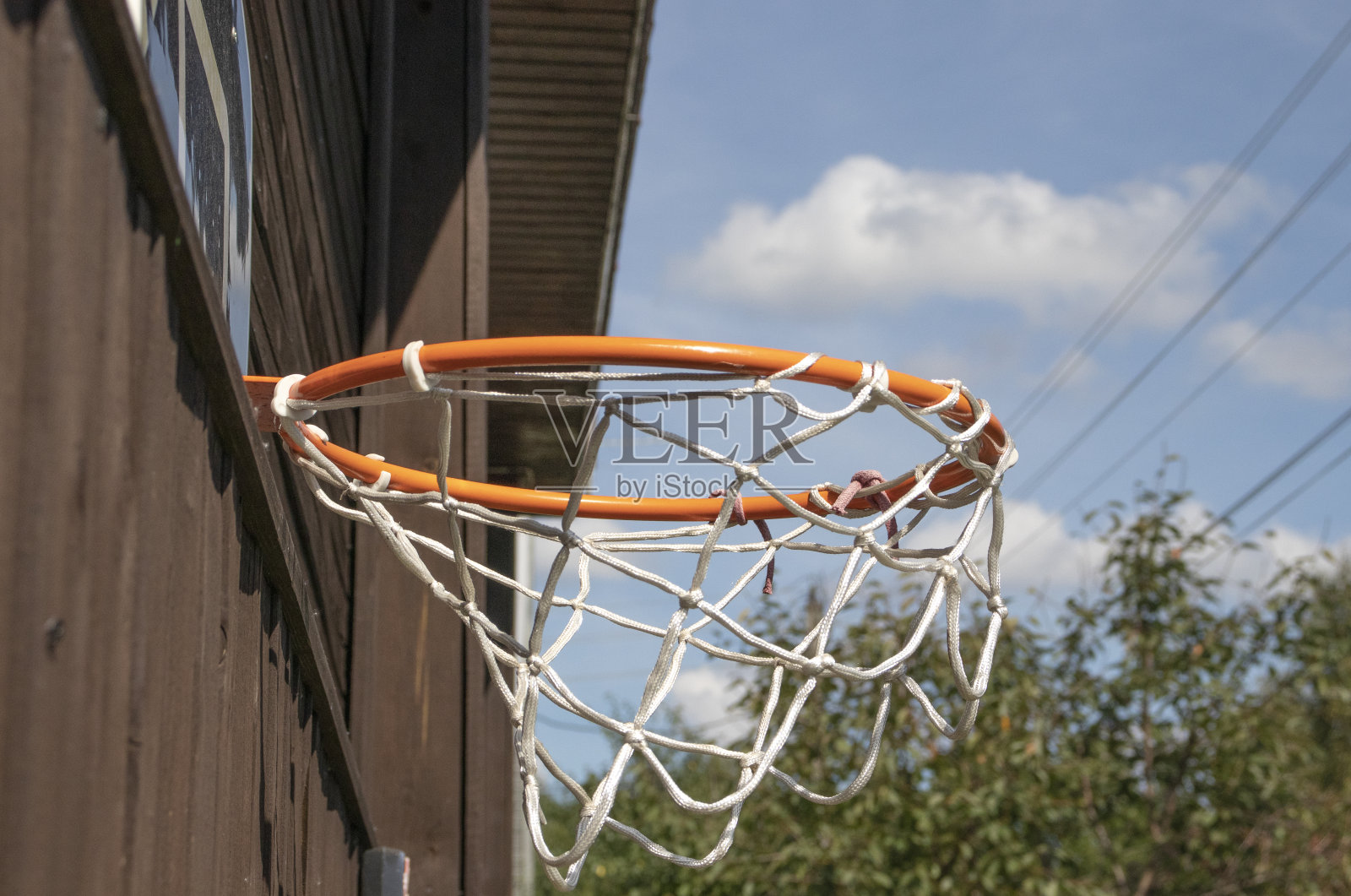 一个棕色的乡村房子上的篮球框照片摄影图片